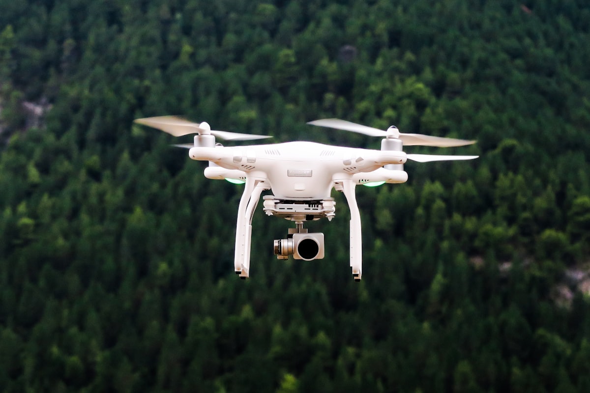 Quadcopter in flight over forest